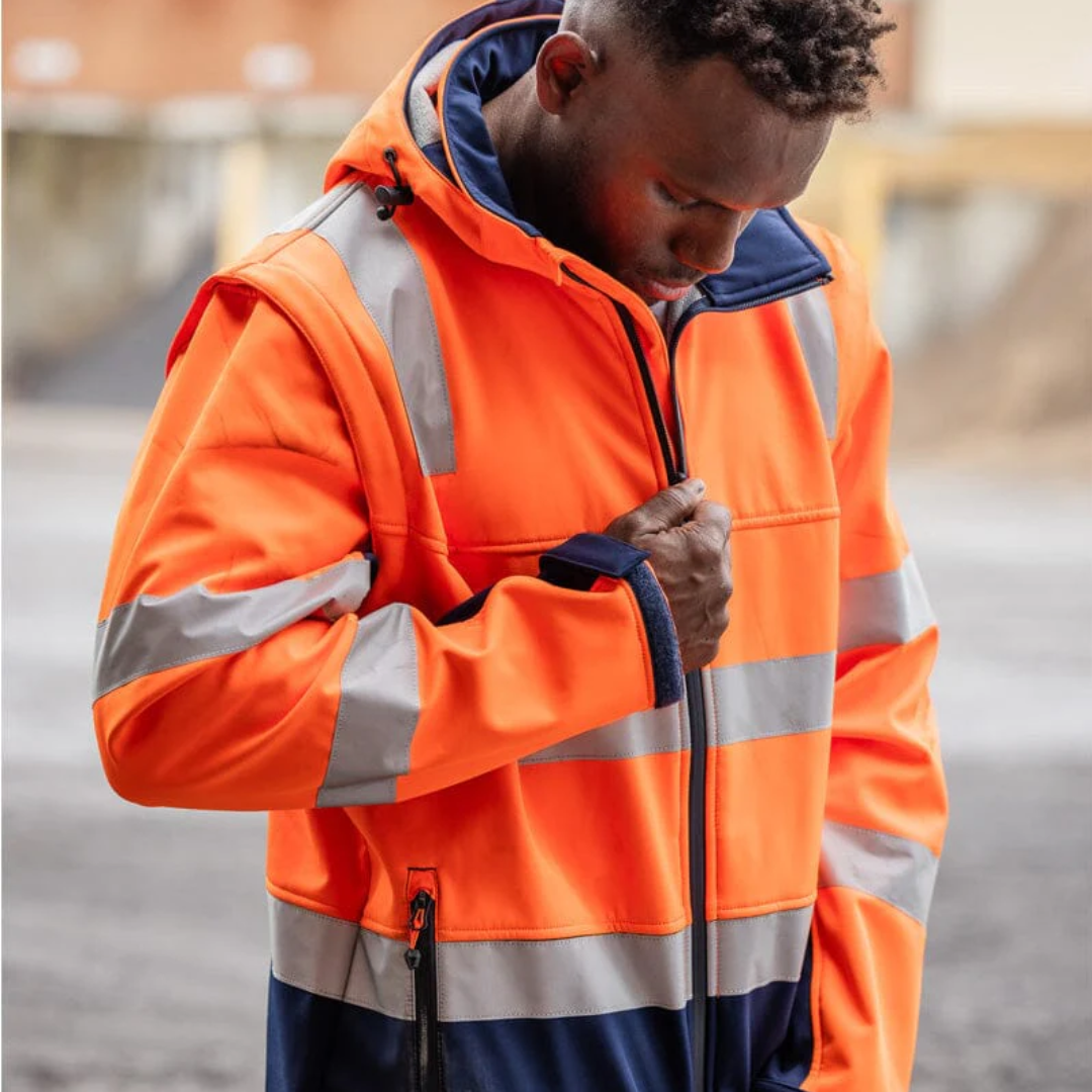 Person wearing an orange high-visibility jacket zipping up the front.